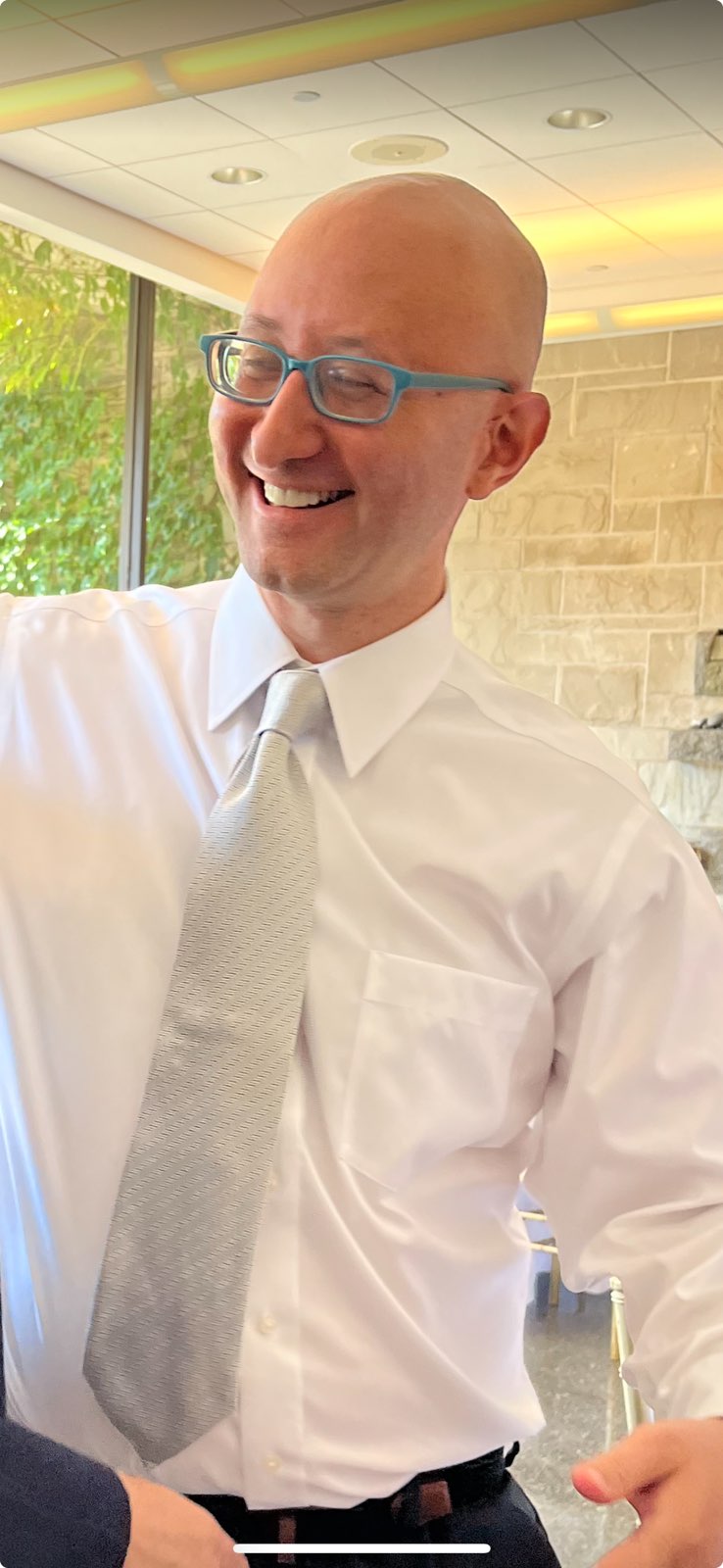 David laughing mid-conversation in a white shirt and silver tie, August 19, 2024